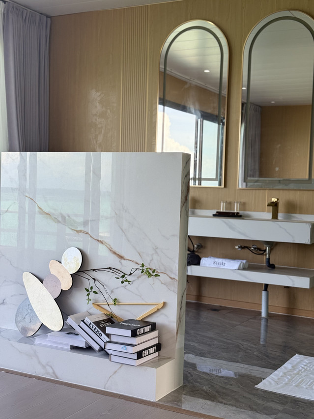 Stylish bathroom featuring marble-style divider with decor at Sicily Hotel
