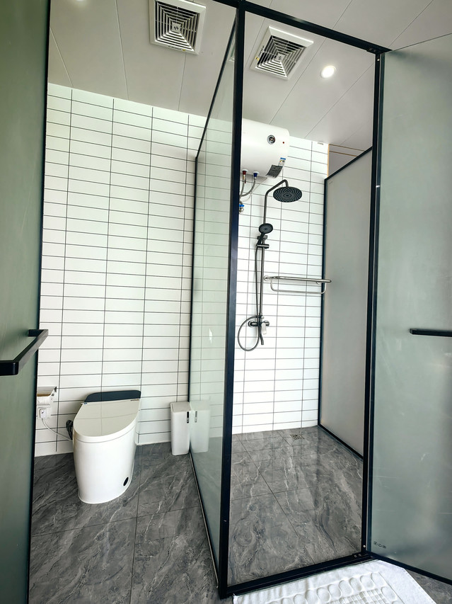 Sleek bathroom featuring glass-enclosed electric shower and smart toilet at Sicily Hotel