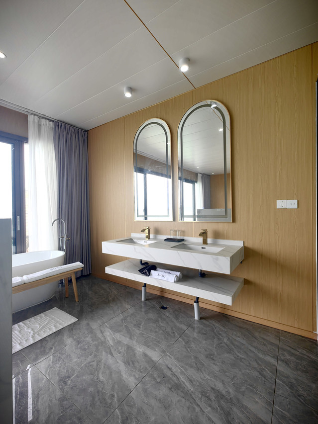 Spacious bathroom featuring floating dual vanity and freestanding tub at Sicily Hotel
