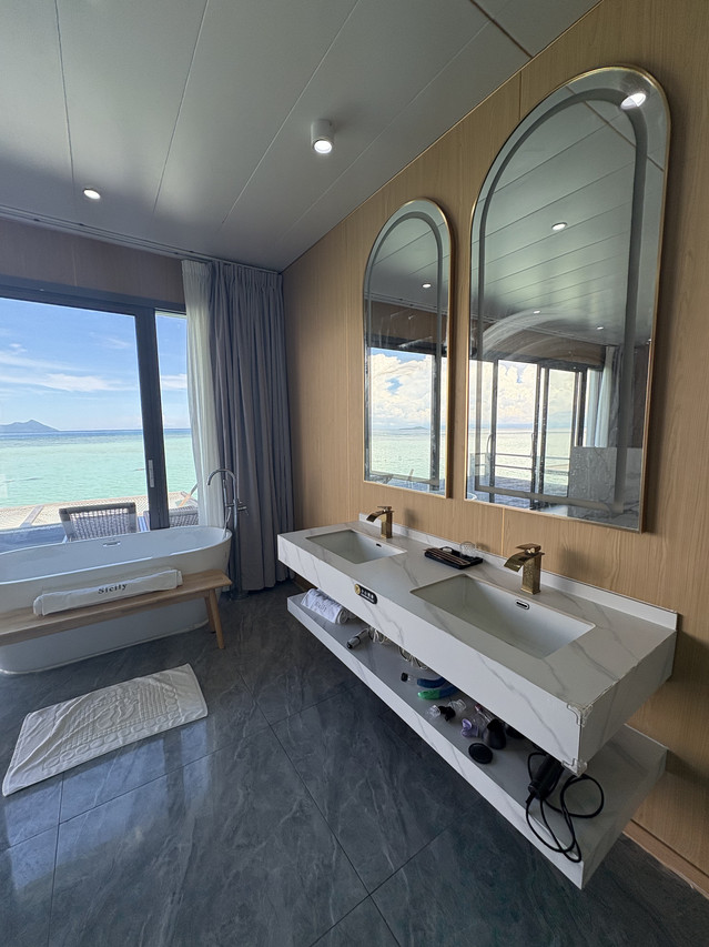 Modern open-concept bathroom at Sicily Hotel featuring freestanding tub