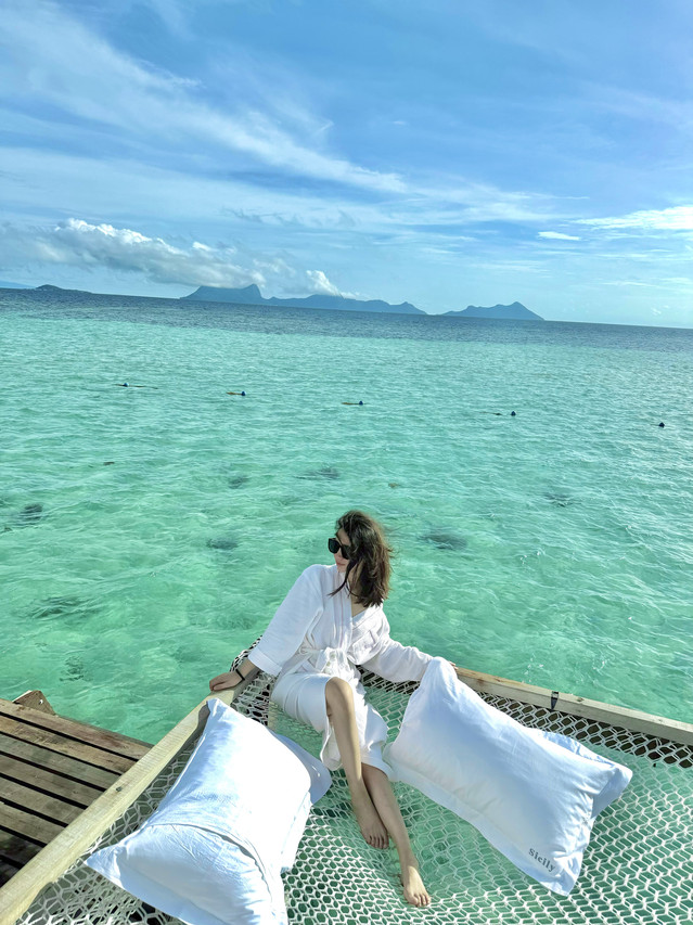 Guest relaxing on a private balcony with catamaran-style net at Sicily Hotel