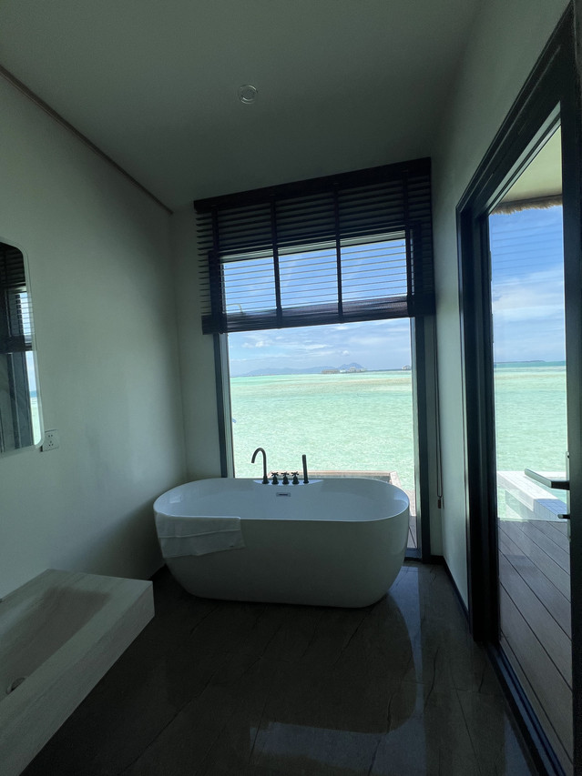 Elegant white bathtub with sleek black fixtures by a window at Sicily Hotel